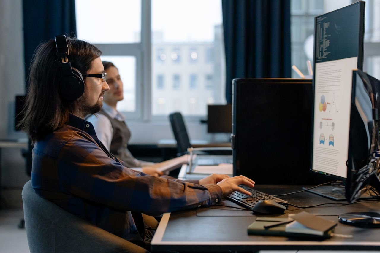 Offerings Two programmers working together with focus on coding in a modern, tech-savvy office environment.